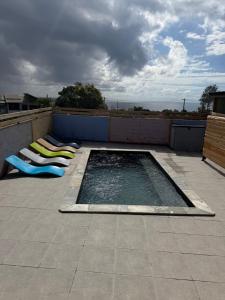 a swimming pool with lounge chairs on a roof at ALHAMBRA location saisonnière in Sainte-Rose