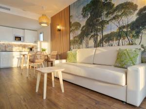 a living room with a white couch and a kitchen at Sunset Suites by Bull Hotels in Puerto Rico de Gran Canaria
