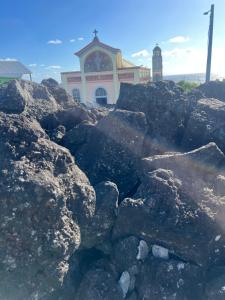 a pile of rocks in front of a church at ALHAMBRA location saisonnière in Sainte-Rose