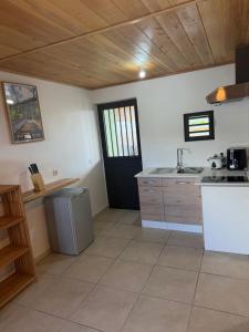 a kitchen with a black door and a sink at ALHAMBRA location saisonnière in Sainte-Rose