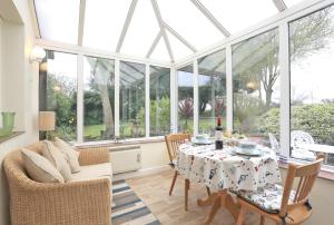 a conservatory with a table and chairs and a room with windows at 1 Bed in Frostenden oc-phc in Frostenden
