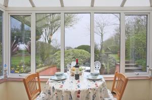 a table with a bottle of wine on it in front of a window at 1 Bed in Frostenden oc-phc in Frostenden