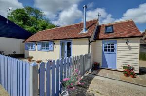 a small white house with a blue fence at 1 Bed in Biddenden oc-cb635 in Biddenden