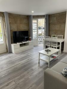 a living room with a flat screen tv and a couch at Ponte Romana in Chaves