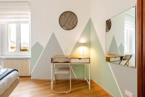 a bedroom with a desk and a wall with geometric shapes at Casa al Castagneto in Trento
