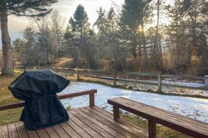 a person sitting on a bench with an umbrella at Teton Shadows Darwin F in Jackson