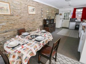 a dining room with a table and a kitchen at Maesgwyn in Cardigan +23 photos