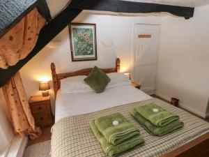 a bedroom with a bed with two green towels on it at Maesgwyn in Cardigan