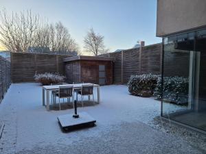 a courtyard with a table and chairs in the snow at Au Paradis Guesthouse in Waregem