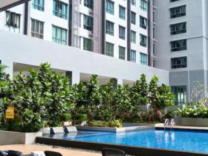 a swimming pool in front of a tall building at ImpianKU MetaStay KL in Seri Kembangan