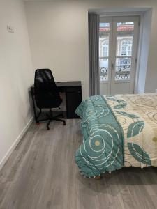 a bedroom with a bed and a desk and a chair at Ponte Romana in Chaves