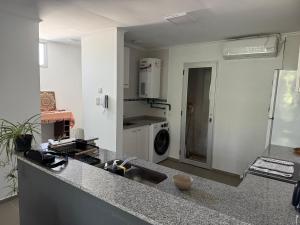 a kitchen with a sink and a washing machine at Iluminado y céntrico in San Nicolás de los Arroyos
