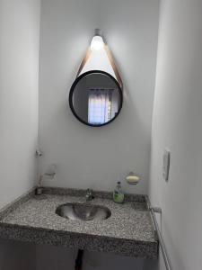a bathroom sink with a mirror on the wall at Iluminado y céntrico in San Nicolás de los Arroyos +6 photos
