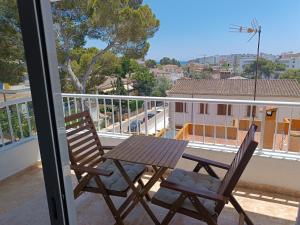 a wooden table and two chairs on a balcony at Hostal Bélgica in Palmanova