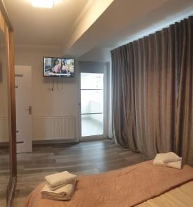 a bedroom with a bed and a tv on the wall at Apartament in Craiova
