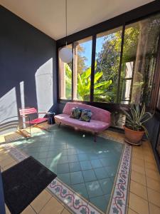 a living room with a pink couch and windows at Villa Cedro in Verbania