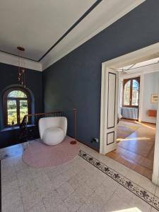 a living room with a white chair and a door at Villa Cedro in Verbania +32 photos
