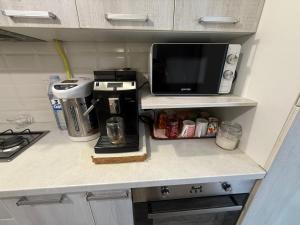 a kitchen counter with a coffee maker and a microwave at 1 Camera Dubla Valea Trandafirilor in Chişinău +1 photo