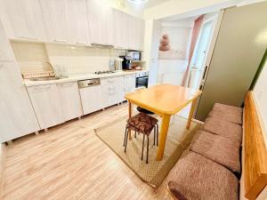 a small kitchen with a table and a couch at 1 Camera Dubla Valea Trandafirilor in Chişinău