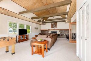 a living room with a couch and a table at 2 Lakefront Cottages with Docks, Bikes, BBQ in Newaygo +36 photos