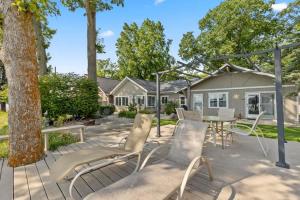 a patio with chairs and a table and a house at 2 Lakefront Cottages with Docks, Bikes, BBQ in Newaygo