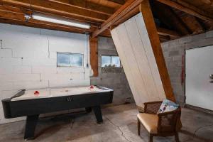 a room with a pool table and a chair at Lakeside Getaway with Dock, Firepit, Grill in Newaygo