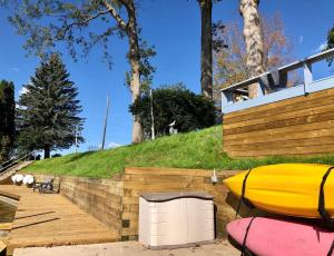 a house with a yellow kayak sitting next to a hill at Waterfront Suite with Dock, Firepit, BBQ in Newaygo