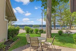 a patio with a table and chairs and a lake at Pet-friendly Cabin with Dock, Firepit, BBQ in Newaygo