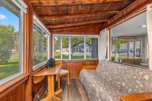 a living room with a couch and windows at Pet-friendly Cabin with Dock, Firepit, BBQ in Newaygo +18 photos
