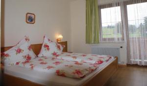 a bed with red and white sheets and pillows at Pension Stammerhof in Schladming