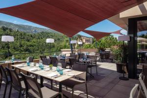 a restaurant with tables and chairs on a patio at Hôtel Sainte Victoire in Vauvenargues