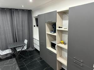 a room with a desk and a table and shelves at Beau studio cosy in Randens