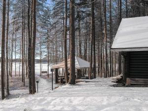 a cabin in the woods with snow on the ground at Holiday Home Tavintupa by Interhome in Pertunmaa