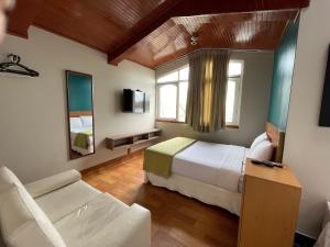 a bedroom with a bed and a couch in a room at Residencial Alfa Hotel in Lima