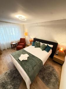 a bedroom with a large bed and a chair at ADA Residence Lupeni acces rapid catre Straja Ski Resort in Lupeni