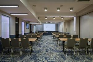 a conference room with tables and chairs and a whiteboard at Hotel Centrum Business in Krakow