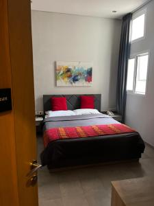 ein Schlafzimmer mit einem Bett mit roten Kissen in der Unterkunft Beit Lebbos Boutique Hotel in Beit ed-Din