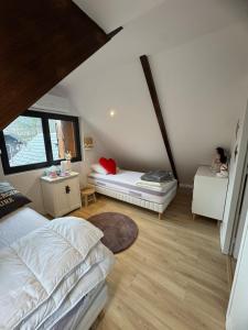 a attic bedroom with two beds and a window at Les Vaillants Chalet - Vielle Aure in Vielle-Aure