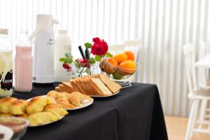 a table topped with plates of bread and fruit at Hotel Parque in Necochea +17 photos