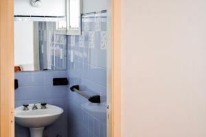 a blue tiled bathroom with a sink and a mirror at Hotel Parque in Necochea