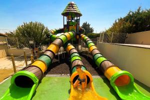a boy is playing on a water slide at a playground at Ludocamping in Lussas