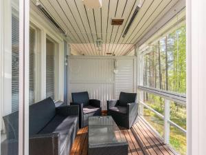 a screened porch with two chairs and a table at Holiday Home Rantalinna 2 by Interhome in Ruokolahti