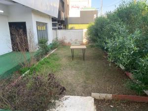 a small garden with a table in the yard at Danzha Royal 4 in Erbil +6 photos
