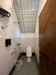 a small bathroom with a toilet in a stall at TauSco Homestay & Campsite - Coorg in Madikeri +45 photos