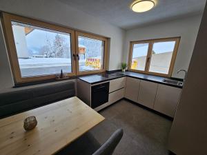 a kitchen with a table and some windows and a table at Apartment Warscher in Ainet