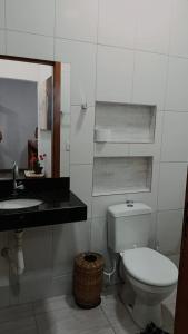 a white bathroom with a toilet and a sink at Chalés do Valle - Arraial D'ajuda in Porto Seguro +10 photos