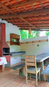 a wooden chair sitting on a patio with a stove at Chalés do Valle - Arraial D'ajuda in Porto Seguro