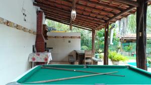 a pool table in a backyard with awning at Chalés do Valle - Arraial D'ajuda in Porto Seguro