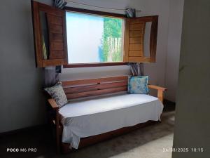 a small bed in a room with a window at Chalés do Valle - Arraial D'ajuda in Porto Seguro