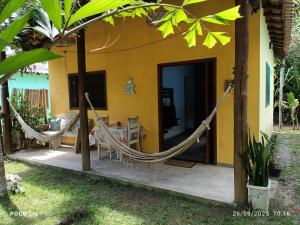 a room with a hammock outside of a house at Chalés do Valle - Arraial D'ajuda in Porto Seguro